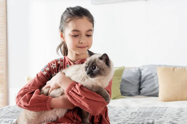 Glückliches Mädchen umarmt pelzige Katze zu Hause im Schlafzimmer — Stockfoto