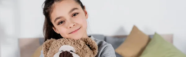 Happy preteen girl with teddy bear smiling at camera, banner — Stock Photo