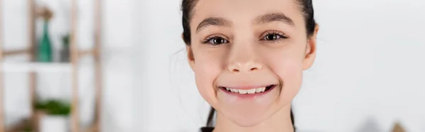 Retrato de menina alegre sorrindo para a câmera em casa, banner — Fotografia de Stock