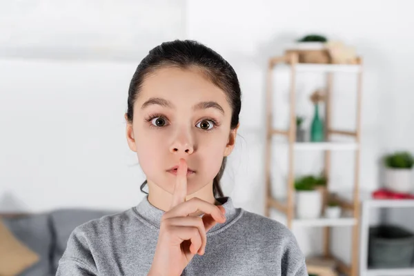 Preteen morena menina olhando para a câmera e mostrando sinal de silêncio — Fotografia de Stock