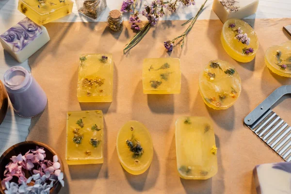 Top view of handmade soap bars on craft paper near dry flowers and supplies — Stock Photo