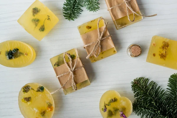 Top view of handmade soap bars near pine branches on table — Stock Photo