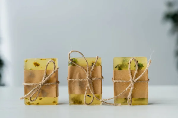 Close up view of handmade soap bars with craft paper and twine on table — Stock Photo