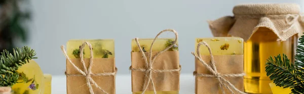 Craft soap bars with twine near jar with honey and spruce branches, banner — Stock Photo