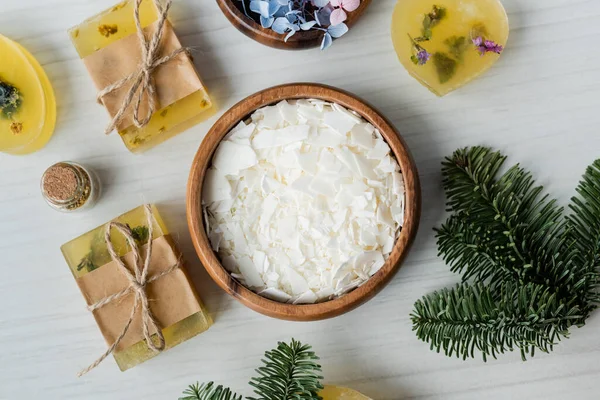 Vue de dessus des flocons de savon sec près des barres et des branches d'épinette sur la table — Photo de stock