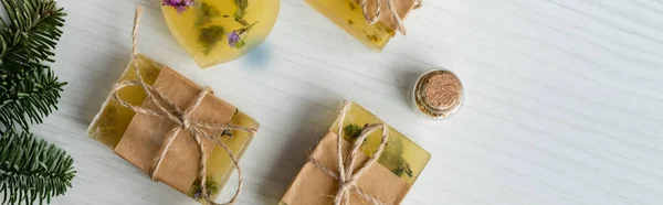 Vue du dessus des barres de savon artisanales près de la branche de pin sur la table, bannière — Photo de stock