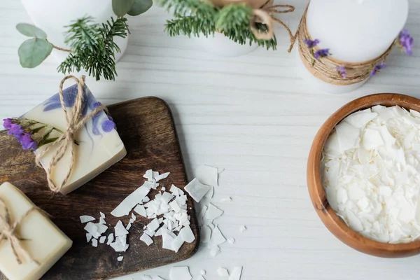 Top view of handmade soap near flakes and candles on table — Stock Photo