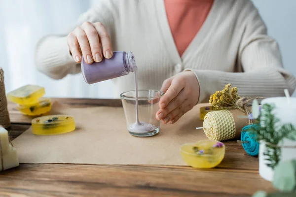 Ausgeschnittene Ansicht einer Kunsthandwerkerin, die Wachs in Glas gießt, in der Nähe handgemachter Kerzen zu Hause — Stockfoto