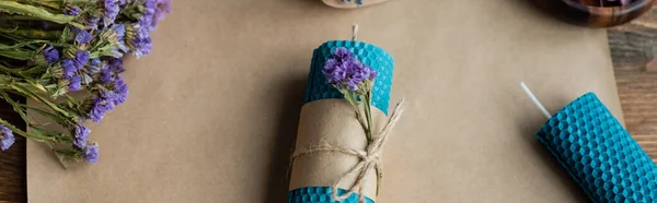 Top view of handmade candle with dry flowers on craft paper on wooden surface, banner — Stock Photo