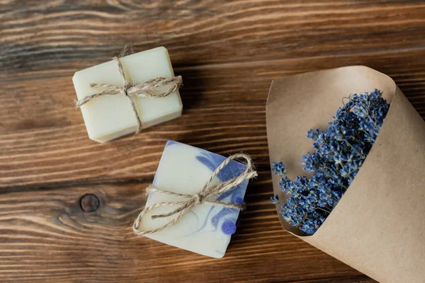 Vue du dessus du bouquet de lavande près du savon artisanal sur une surface en bois — Photo de stock