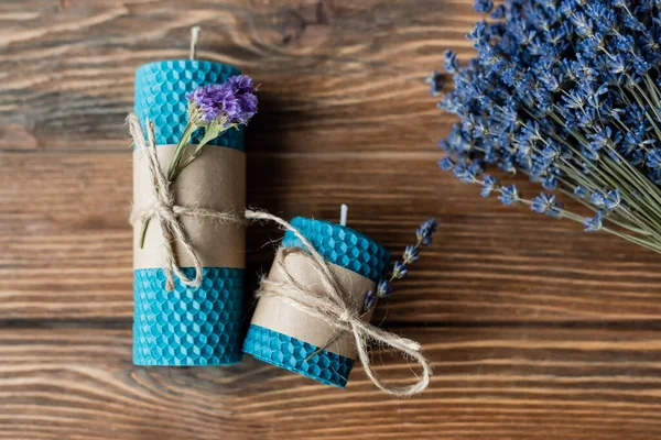 Vista superior de velas hechas a mano y flores de lavanda en la superficie de madera - foto de stock