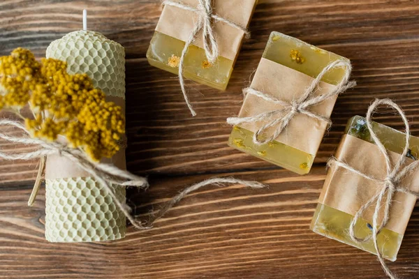 Top view of handmade candle and soap bars with twine on wooden surface — Stock Photo