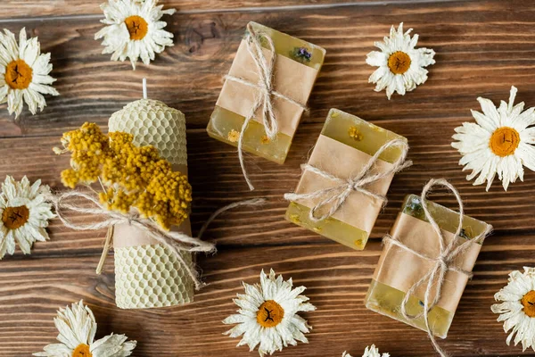 Top view of craft candle and soap near dry flowers on wooden surface — Stock Photo