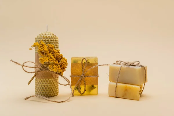 Handmade candle and soap bars with twine on beige background — Stock Photo