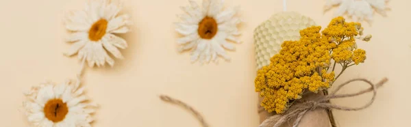 Top view of handmade candle near dry flowers on beige background, banner — Stock Photo