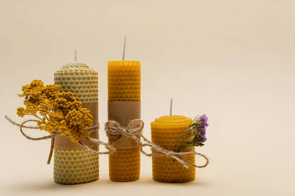 Handgemachte Kerzen mit trockenen Blumen auf beigem Hintergrund — Stockfoto