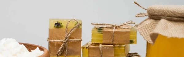 Close up view of handmade soap bars and flakes near honey isolated on grey, banner — Stock Photo