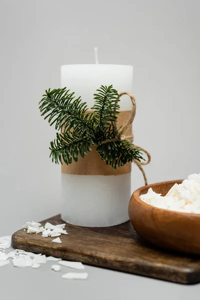 Vue rapprochée de la bougie artisanale près de la cire sèche sur une planche de bois sur fond gris — Photo de stock