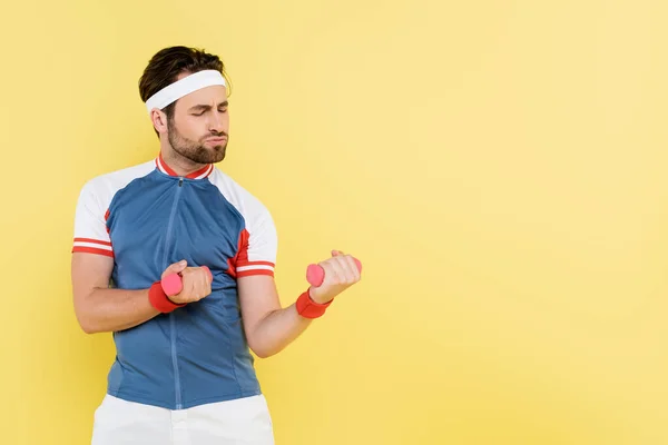 Sportsman dans l'entraînement de veste de sport avec haltères isolés sur jaune — Photo de stock