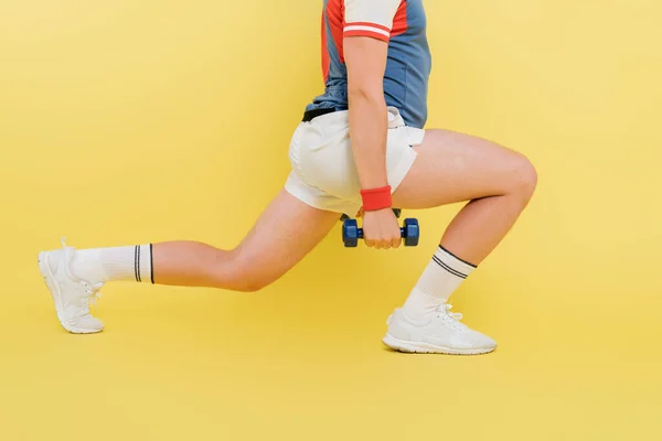 Vista cortada de treinamento desportivo com halteres no fundo amarelo — Fotografia de Stock