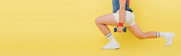 Cropped view of sportsman working out with dumbbells on yellow background. banner — Stock Photo