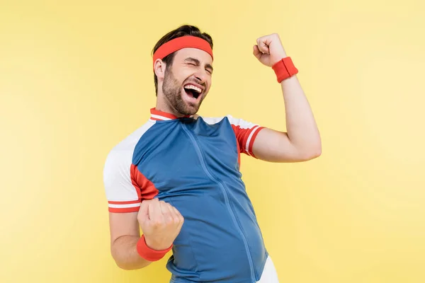 Excited sportsman in sports jacket showing yes gesture isolated on yellow — Stock Photo