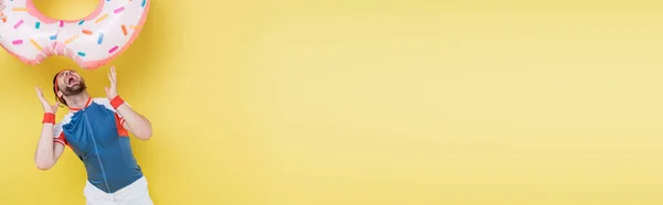Sportsman apertura bocca sotto anello nuoto su sfondo giallo, banner — Foto stock