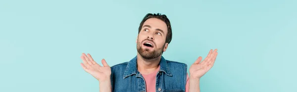 Young shocked man looking away isolated on blue, banner — Stock Photo