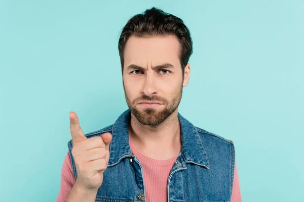 Serious man looking and pointing with finger at camera isolated on blue — Stock Photo