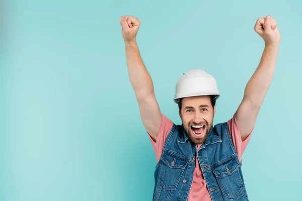 Eccitato uomo in casco mostrando sì gesto isolato sul blu — Foto stock