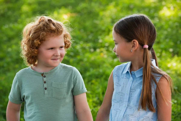 Brother and sister looking at each other outdoors — Stock Photo