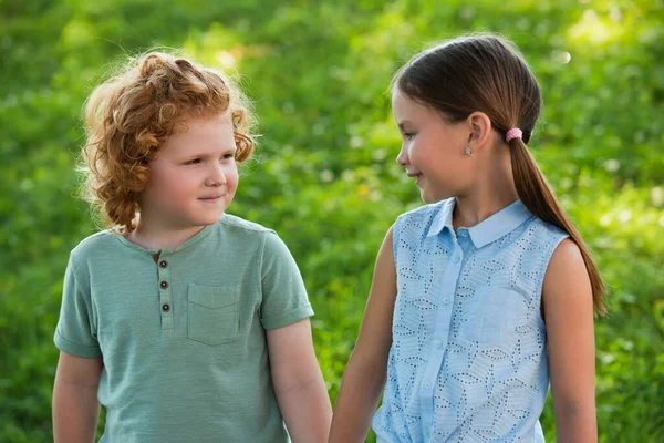 Positive girl and boy looking at each other outdoors — Stock Photo