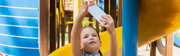 Fille prenant selfie sur téléphone mobile dans le parc d'attractions, bannière — Photo de stock