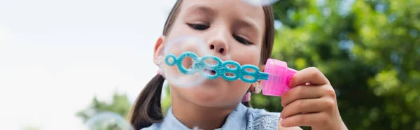 Close up view of girl blowing soap bubbles outdoors, banner — Stock Photo