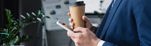 Abgeschnittene Ansicht des Ökonomen mit Coffee to go-Nachrichten auf dem Handy im Büro, Banner — Stockfoto