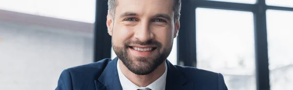 Empresário barbudo alegre sorrindo para a câmera no escritório, banner — Fotografia de Stock