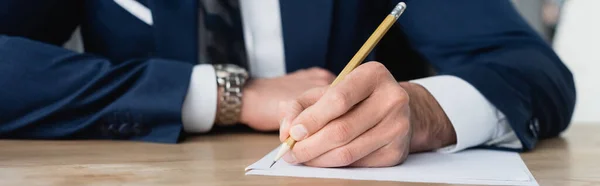 Vista parcial de la escritura del economista con el lápiz en la oficina, bandera - foto de stock