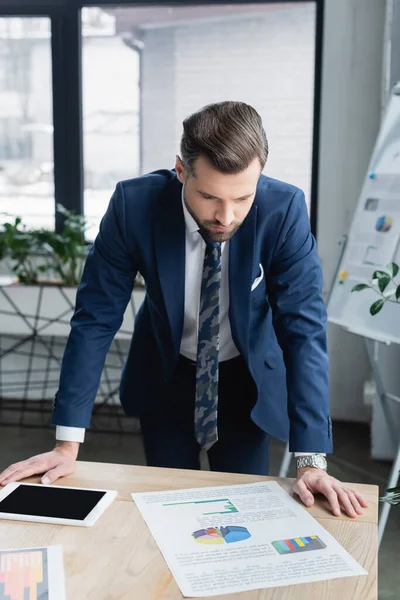 Brünetten Ökonomen Blick auf Analytik in der Nähe von digitalen Tablet mit leerem Bildschirm — Stockfoto