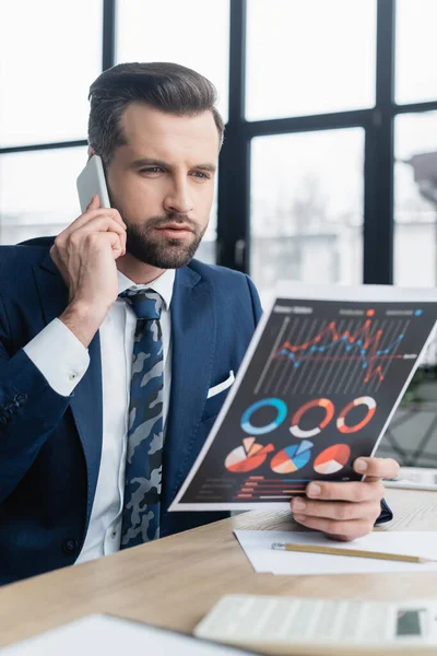 Ökonom betrachtet Analytik während eines Telefongesprächs im Büro — Stockfoto