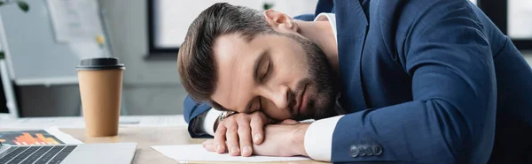 Exhausted economist sleeping at workplace near coffee to go, banner — стоковое фото