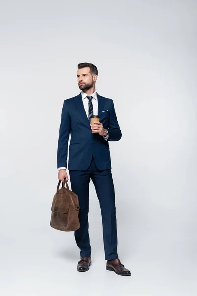 Full length view of economist with leather briefcase and coffee to go on black — Stock Photo