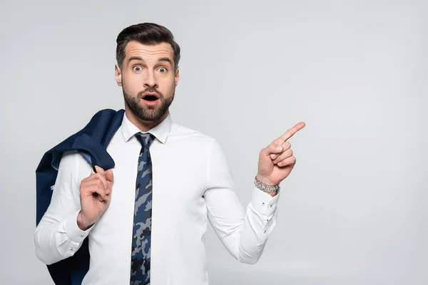 Hombre de negocios sorprendido en camisa blanca señalando con el dedo aislado en gris - foto de stock