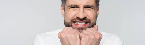 Nervöser Geschäftsmann mit Fäusten in Gesichtsnähe isoliert auf grauem Banner — Stockfoto