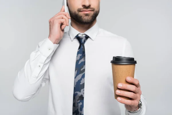 Vue recadrée de l'homme d'affaires avec café pour aller parler sur téléphone cellulaire isolé sur gris — Photo de stock