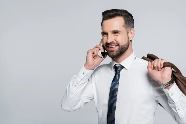 Fröhlicher Geschäftsmann im weißen Hemd, der mit dem Smartphone telefoniert und isoliert auf grau blickt — Stockfoto