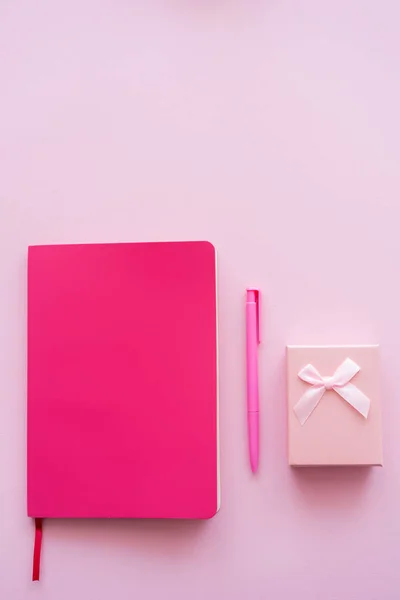 Draufsicht auf Geschenkbox, helles Notizbuch und Stift isoliert auf rosa — Stockfoto