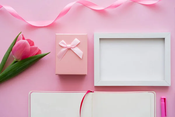 Vue du dessus de la tulipe près du cadre, carnet vierge et boîte cadeau sur rose — Photo de stock