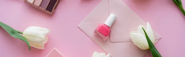 Top view of white tulips near envelope and nail polish on pink, banner — Stock Photo