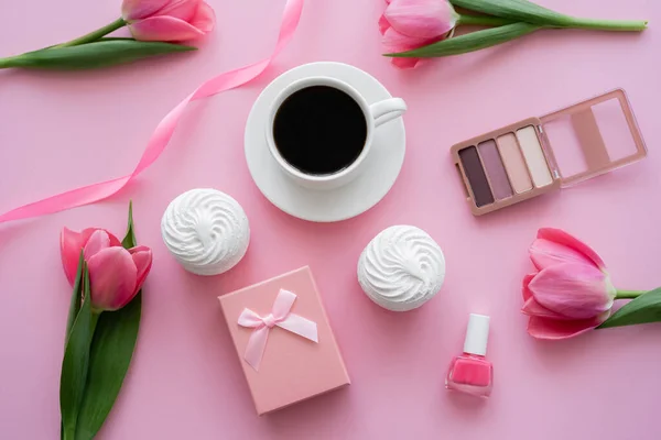 Zephyr, dekorative Kosmetik und Tulpen in der Nähe einer Tasse Kaffee auf rosa — Stockfoto
