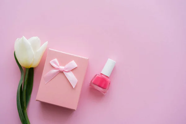 Draufsicht auf weiße Tulpe, Geschenkbox und Nagellack auf rosa — Stockfoto